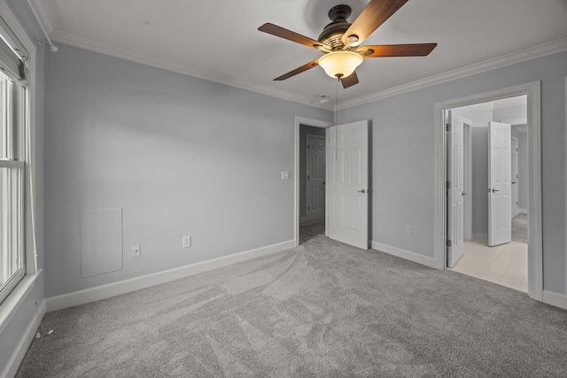 unfurnished bedroom with crown molding, light colored carpet, and ceiling fan