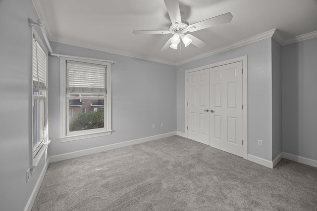 unfurnished bedroom featuring crown molding, light colored carpet, ceiling fan, and a closet