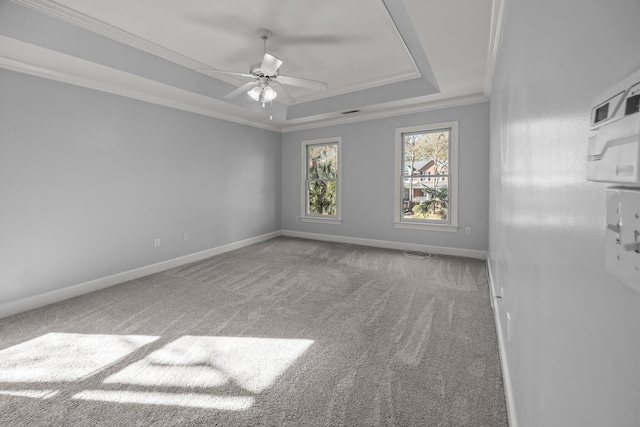 carpeted spare room featuring crown molding, ceiling fan, and a tray ceiling