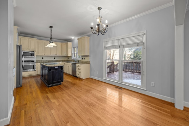 kitchen with hanging light fixtures, crown molding, a center island, and stainless steel appliances