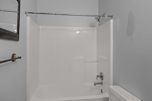 bathroom with shower / bathing tub combination and toilet