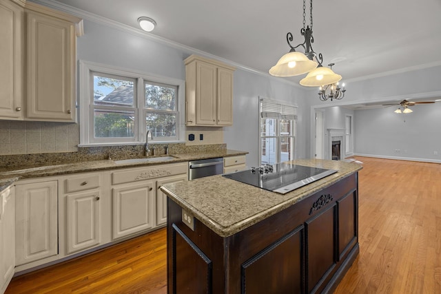 kitchen with sink, crown molding, stainless steel dishwasher, pendant lighting, and black electric stovetop