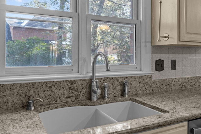 interior details with tasteful backsplash, sink, and light stone counters