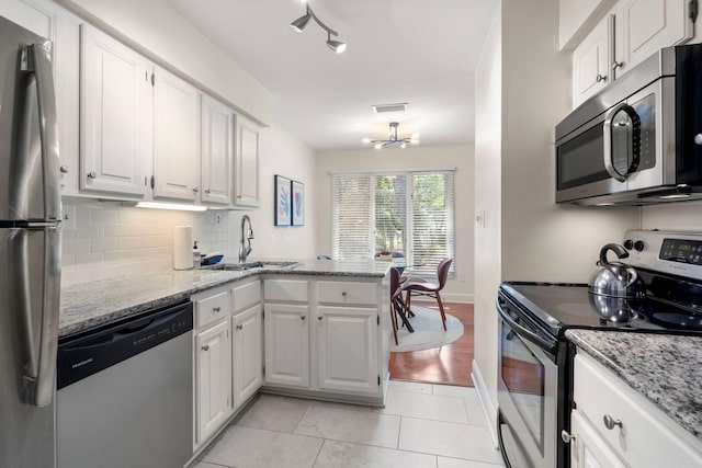 5558 Green Dolphin Way, Kiawah Island, SC 29455 - kitchen with appliances with stainless steel finishes, white cabinets, and a peninsula