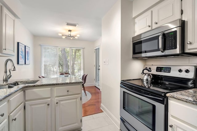 5558 Green Dolphin Way, Kiawah Island, SC 29455 - kitchen featuring stainless steel appliances, white cabinetry, light stone counters, light tile patterned flooring, and backsplash