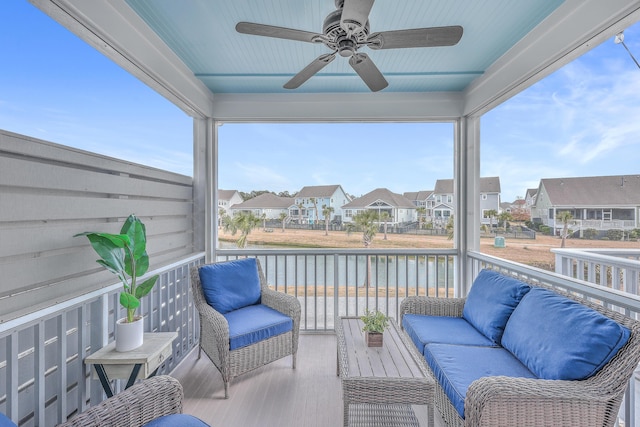 sunroom featuring a water view and ceiling fan