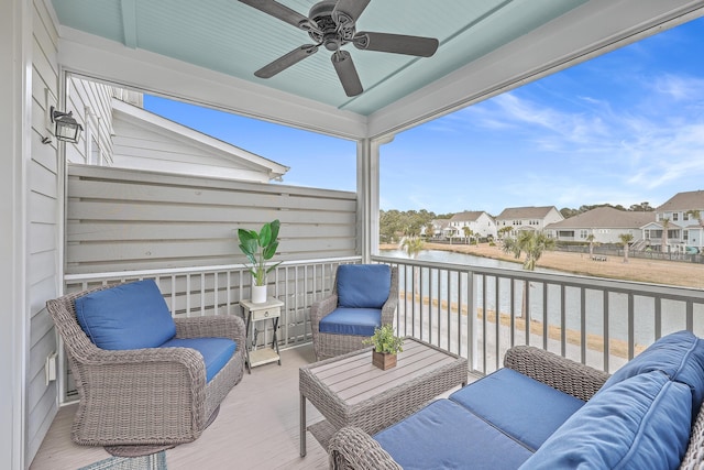 balcony featuring an outdoor hangout area, ceiling fan, and a water view