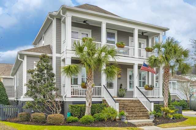 view of front of house with stairway, covered porch, ceiling fan, and a balcony