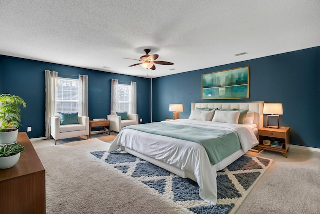 carpeted bedroom with ceiling fan and a textured ceiling