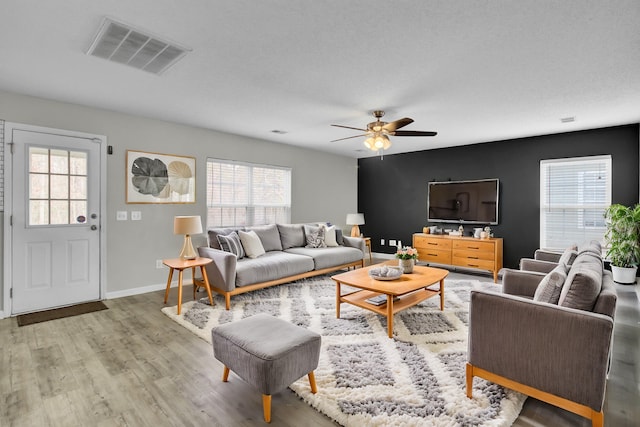 living room featuring hardwood / wood-style flooring, ceiling fan, and a healthy amount of sunlight