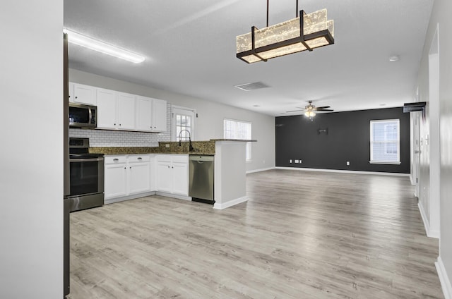 kitchen featuring white cabinetry, light hardwood / wood-style flooring, appliances with stainless steel finishes, pendant lighting, and ceiling fan