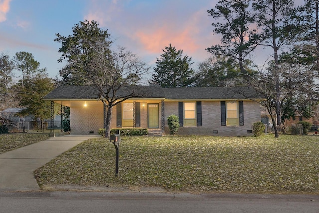 ranch-style house featuring a carport and a yard