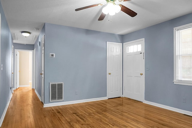 entryway with ceiling fan, wood-type flooring, and plenty of natural light