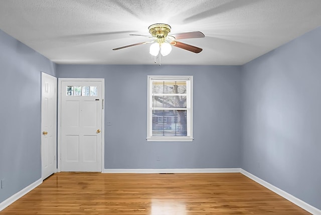 foyer entrance with ceiling fan, hardwood / wood-style floors, and a textured ceiling