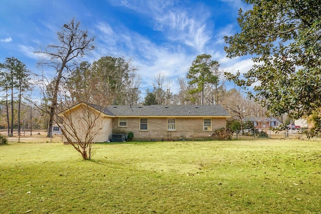 back of house featuring central AC unit and a lawn