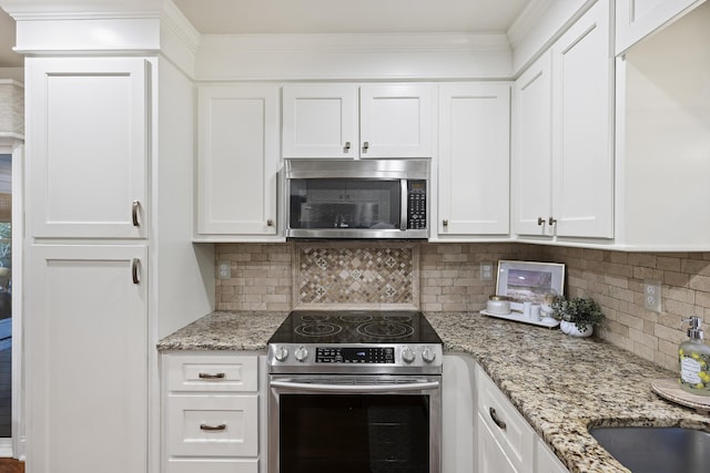 kitchen featuring backsplash, stainless steel appliances, and white cabinetry