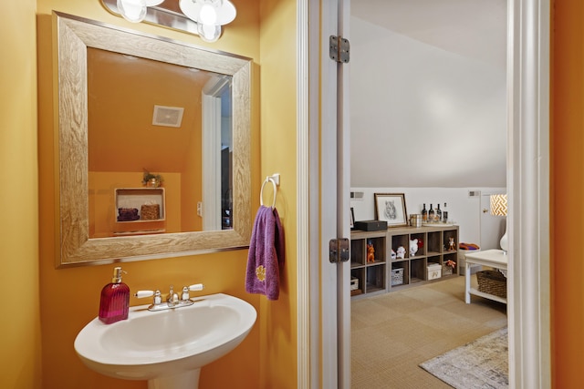 bathroom with lofted ceiling and sink