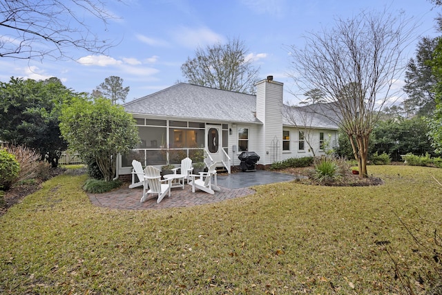 back of property featuring a sunroom, a yard, and a patio