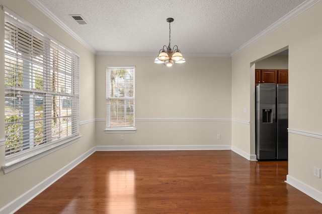 unfurnished room featuring a chandelier, dark wood-type flooring, a textured ceiling, and ornamental molding