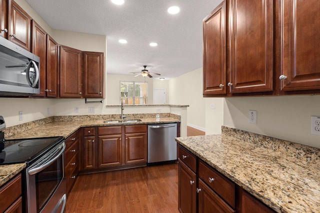 kitchen with sink, ceiling fan, a textured ceiling, appliances with stainless steel finishes, and dark hardwood / wood-style flooring