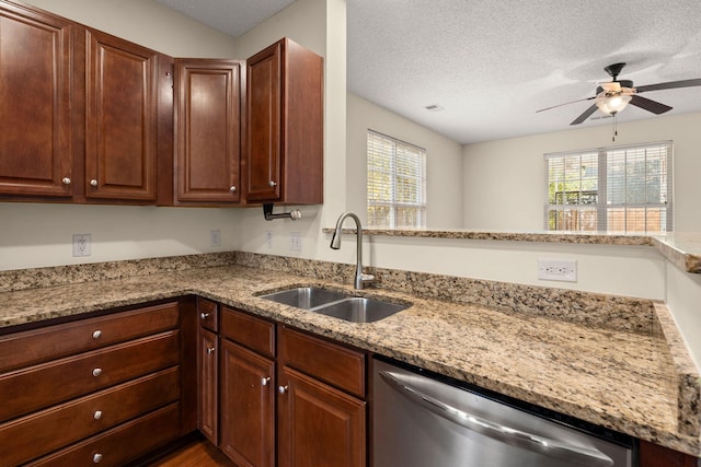 kitchen with a textured ceiling, stainless steel dishwasher, a healthy amount of sunlight, and sink