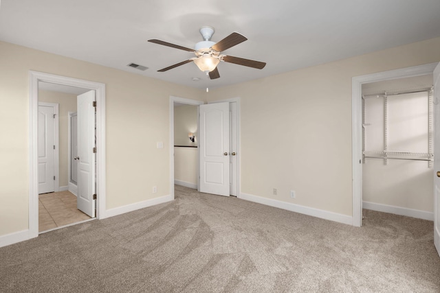 unfurnished bedroom featuring ceiling fan, a closet, and light colored carpet