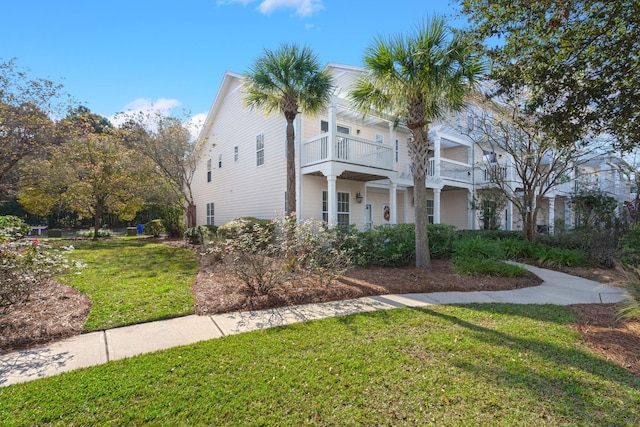 view of front of home featuring a balcony and a front lawn