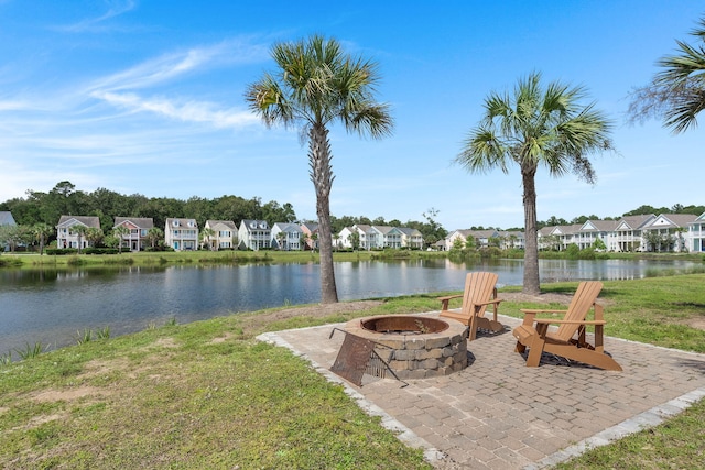 exterior space featuring a patio, a water view, and a fire pit