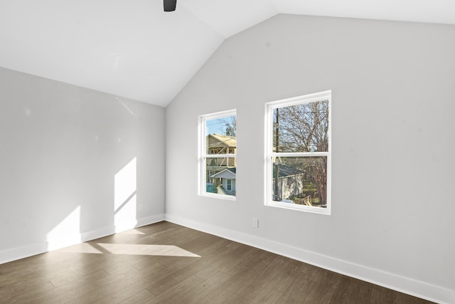 spare room with ceiling fan, dark wood-type flooring, and vaulted ceiling