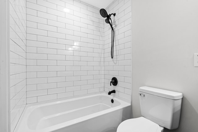 bathroom featuring toilet and tiled shower / bath