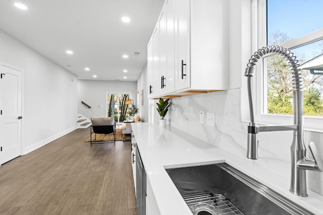 kitchen with decorative backsplash, white cabinetry, dark hardwood / wood-style flooring, and sink