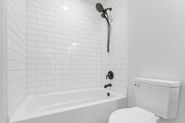 bathroom with toilet and tiled shower / bath