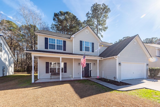 view of property featuring a porch, a front lawn, and a garage