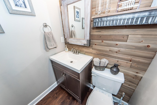 bathroom with toilet, hardwood / wood-style flooring, and vanity