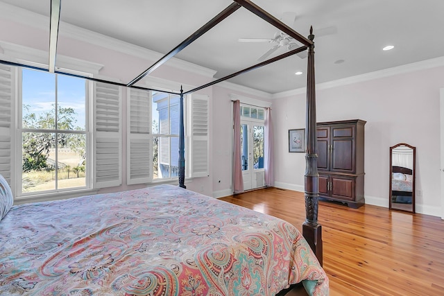 bedroom with light wood-style flooring, multiple windows, baseboards, and ornamental molding