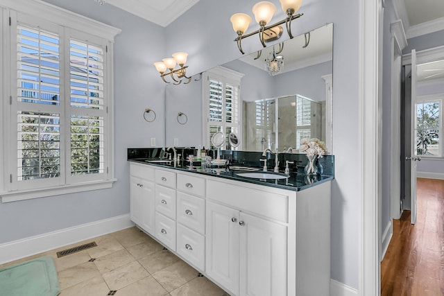 full bath featuring visible vents, a stall shower, a sink, an inviting chandelier, and crown molding