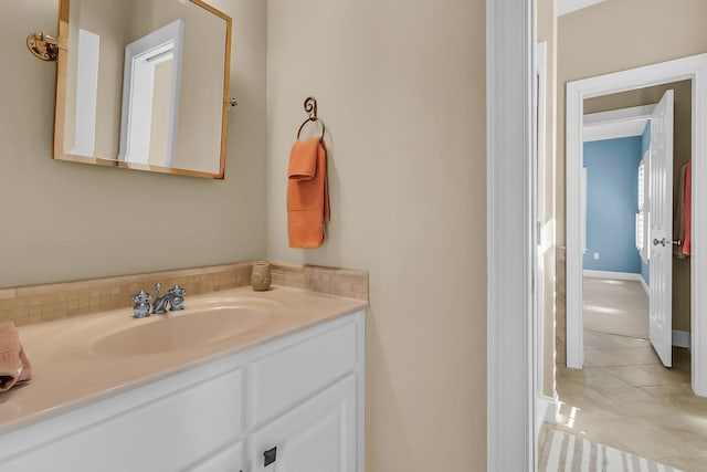 bathroom featuring tile patterned floors, baseboards, and vanity