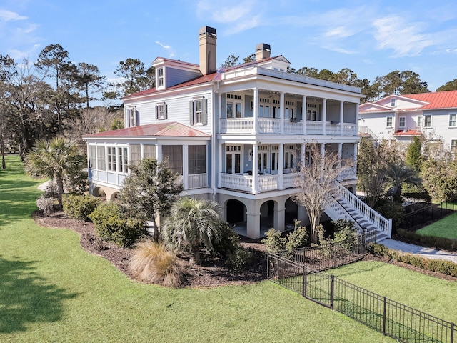 rear view of house with a yard, fence private yard, stairs, and a balcony