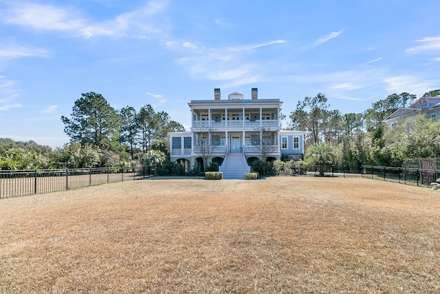 back of property featuring stairway, a chimney, a balcony, and fence