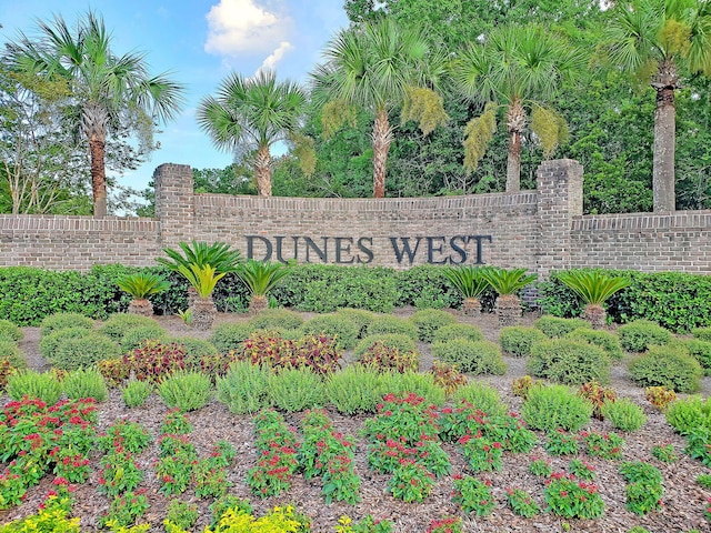 community / neighborhood sign featuring fence