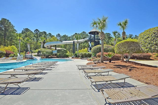 pool with a water slide and a patio area