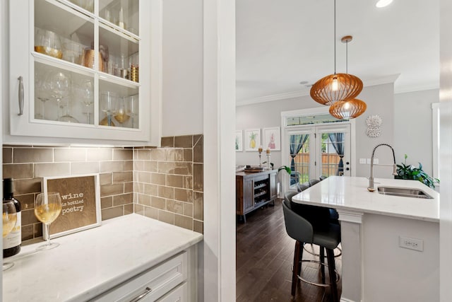 525 Yellow Tower Ter, Charleston, SC 29412 - kitchen featuring ornamental molding, glass insert cabinets, white cabinets, a breakfast bar area, and light stone countertops
