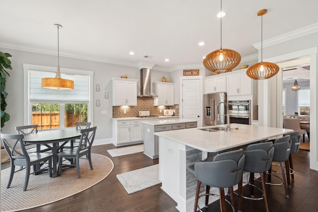 525 Yellow Tower Ter, Charleston, SC 29412 - kitchen with wall chimney range hood, a center island with sink, stainless steel appliances, dark wood-style flooring, and white cabinetry