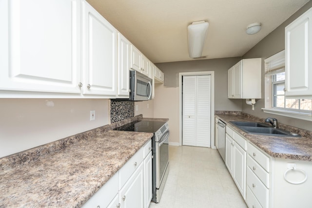 kitchen with visible vents, stainless steel appliances, light floors, white cabinetry, and a sink