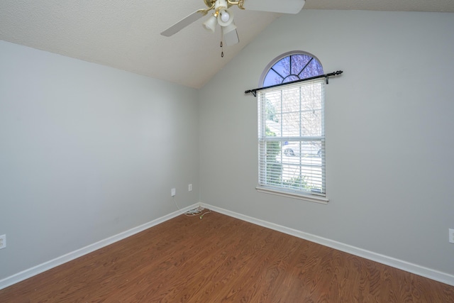 spare room featuring lofted ceiling, ceiling fan, a textured ceiling, wood finished floors, and baseboards