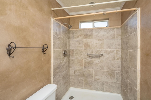 bathroom with a tile shower, toilet, and crown molding