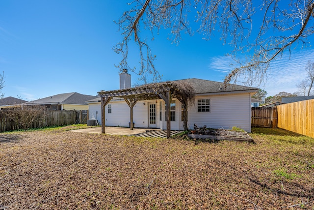 back of house with a lawn, a patio, a fenced backyard, a chimney, and a pergola