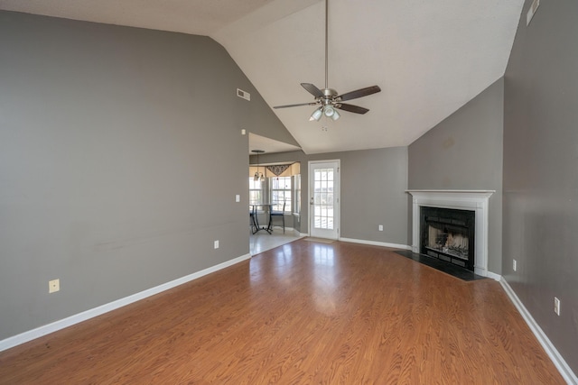 unfurnished living room featuring visible vents, a fireplace with flush hearth, ceiling fan, wood finished floors, and baseboards