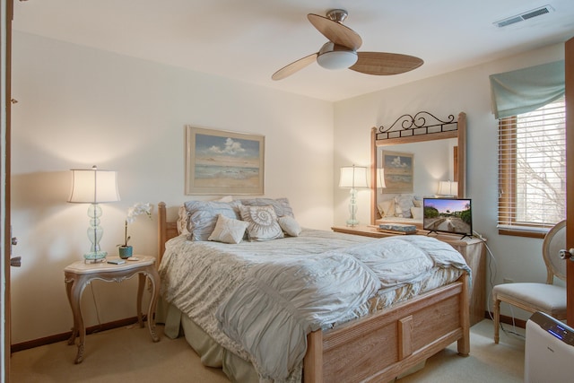 carpeted bedroom featuring a ceiling fan and visible vents