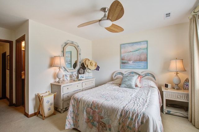 bedroom featuring ceiling fan, visible vents, baseboards, and light colored carpet